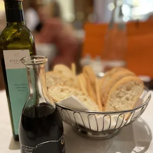 a bowl of bread and a bottle of olive oil