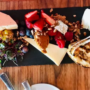 a plate of cheese, fruit, and bread
