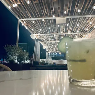 a cocktail with a cucumber garnish