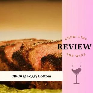 a piece of steak on a plate with a glass of wine