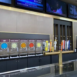a row of beer taps and televisions