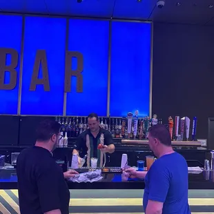 two men standing at the bar
