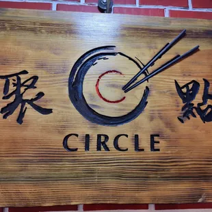 a wooden sign with chopsticks on it