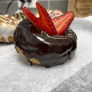 a chocolate donut with strawberries on top
