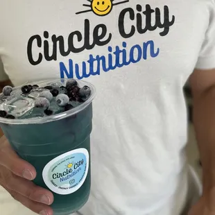 a man holding a cup of blueberry yogurt