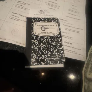 The bill arrives in a little composition book. People leave reviews in them.