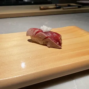 a piece of sushi on a cutting board