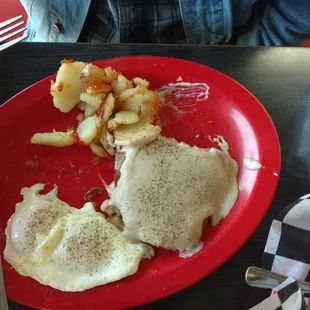 Country fried steak with fried potatoes.
