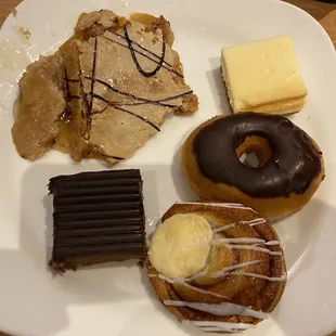 Peach cobbler, cheesecake, chocolate doughnut, cheese danish, and brownie