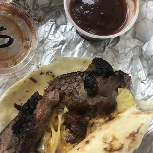 Brisket taco with eggs and cheese and spicy sauce