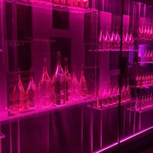 a bar with wine glasses on the shelves