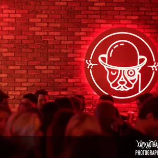 a crowd of people standing in front of a brick wall