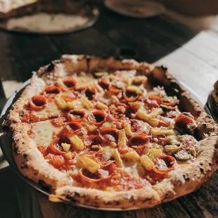 a pizza with pepperoni, peppers, and cheese