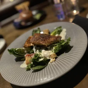 Blackened salmon on Caesar salad.