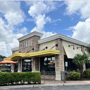 the front of a restaurant with a yellow awning