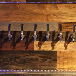 a row of beer taps on a wooden wall