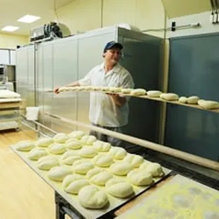 a baker holding a tray of bread