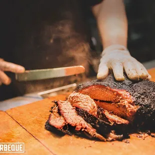a man cutting a brisked beef