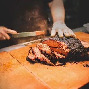 a man cutting up meat on a cutting board