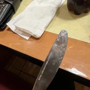 a knife, napkins, and a purse on a table