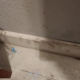 Filthy baseboards and nail polish on floor.