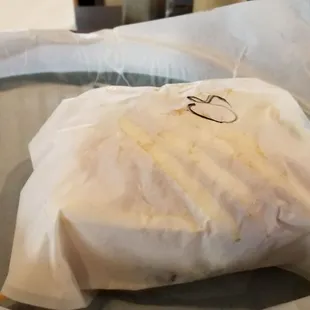 a sandwich wrapped in a paper bag