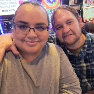 a man and a woman sitting in front of a slot machine