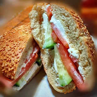 Cucumber tomato with cream cheese on a sesame bagel.