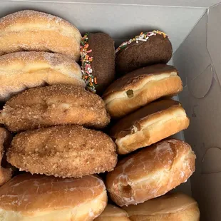 Sugar donut, jelly filled donut, sprinkle donut, chocolate custard filled donut, spiral maple donut, and apple donut