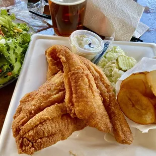 Flounder platter includes coleslaw, potatoes, salad, and hush puppies