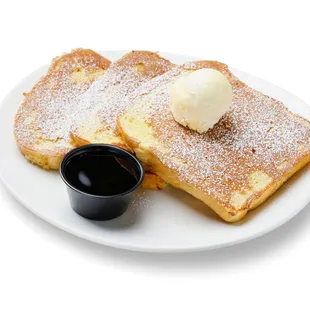 a plate of french toast with butter and syrup