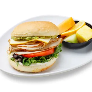 a chicken sandwich with a side of fruit