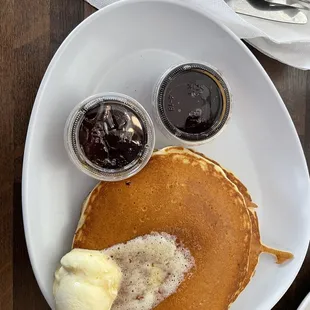 a plate of pancakes with butter and syrup