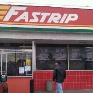 a man standing in front of a fastrip store