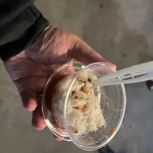 a hand holding a cup of ice cream