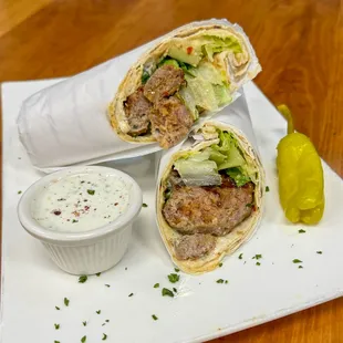 Wrap Ground lamb and beef patties (kofte) with peppers, onions, and parsley. with Pita Bread, Salad and Rice.