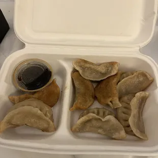Pan fried chicken dumplings with dipping sauce.