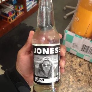 a person holding a bottle of jones cream soda