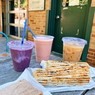 a sandwich, smoothie, and smoothie on a picnic table
