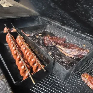 a grill with meat and sausages on skewers