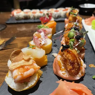 a variety of sushi on a slate platter