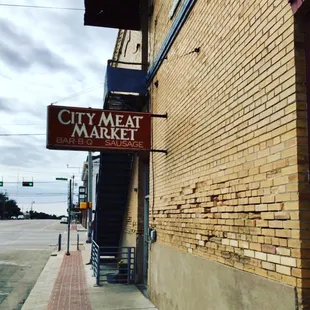 a brick building with a sign that says city meat market