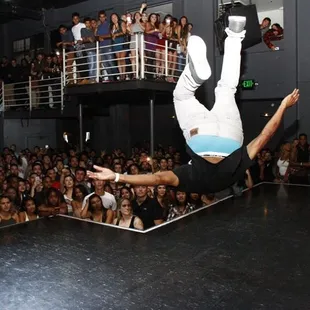 a man doing a handstand in front of a crowd