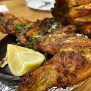 a plate of fried fish with a lemon wedge