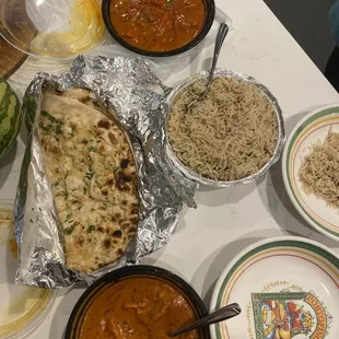 top dish: Chicken Tikka Masala, garlic naan, bottom dish: Butter Chicken