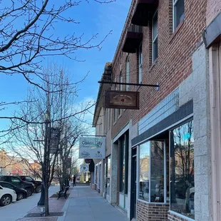a sidewalk in front of a brick building