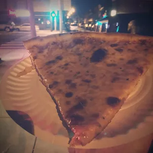 a slice of pizza on a paper plate