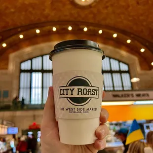 a hand holding a coffee cup