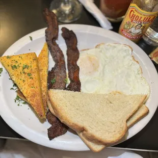 DELUXE 2 eggs Over Medium , Bacon, seared grits, and homemade sourdough toast