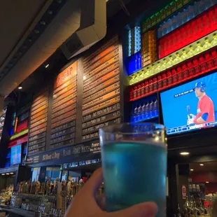 a hand holding a blue drink